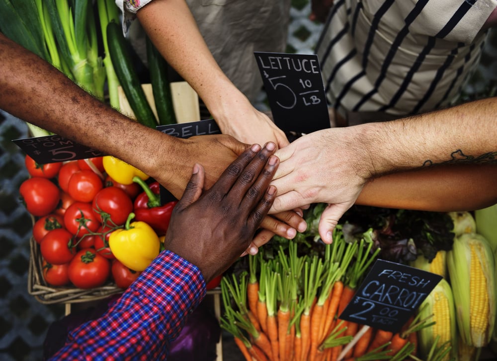 people holding hands collaborating on reducing food waste